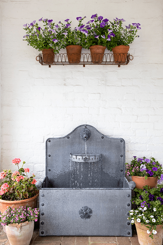 A water feature with marginal plants, enhancing the water feature with plants that soften the edges